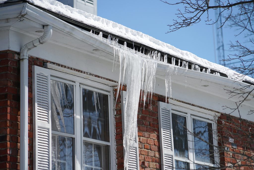 icicle and ice dam on the house roof in winter season jng services