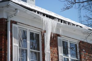 icicle and ice dam on the house roof in winter season jng services